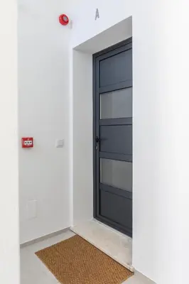 a black door in a white room with a rug at Correeira Luxury Residence in Albufeira