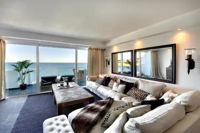 a living room with a large couch and a large window at Casa Latino - Oceanfront - Luxury & Charming villa- Jacuzzi at Rooftop by DreamvillasAlbufeira in Albufeira