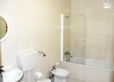 a bathroom with a toilet and a shower and a sink at Apartamentos Encosta do Mar in Albufeira