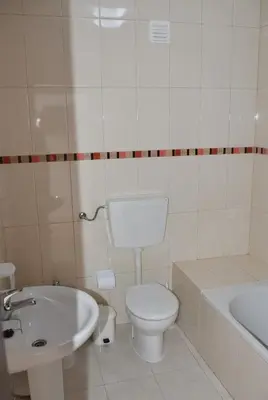 a bathroom with a toilet and a sink and a tub at Apartamentos Encosta do Mar in Albufeira