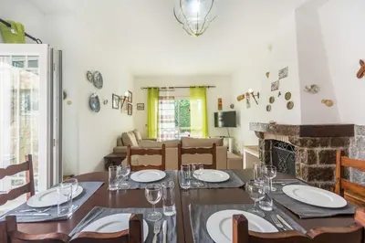 a dining room with a table and a fireplace at Oura Villa V3 com Piscina Privada in Albufeira