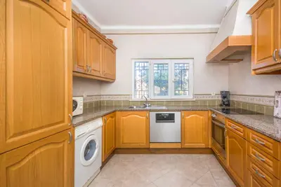 a kitchen with wooden cabinets and a washer and dryer at Oura Villa V3 com Piscina Privada in Albufeira