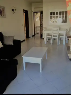 a living room with a couch and a table and chairs at Rêve au Soleil in Albufeira