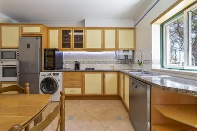 a kitchen with yellow cabinets and a sink and a dishwasher at Villa Moises in Albufeira