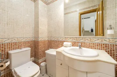 a bathroom with a toilet and a sink and a mirror at Villa Moises in Albufeira