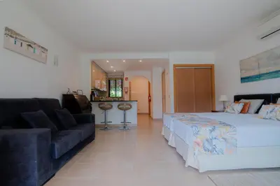 a bedroom with a large bed and a couch at Coastal Retreat with Pool and Beach Access by Drago Rentals in Albufeira