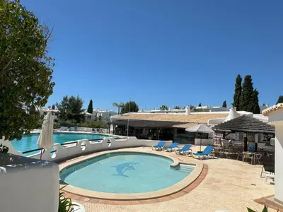 a large swimming pool with chairs and umbrellas at Coastal Retreat with Pool and Beach Access by Drago Rentals in Albufeira
