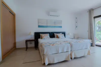 a white bedroom with two beds and a window at Coastal Retreat with Pool and Beach Access by Drago Rentals in Albufeira