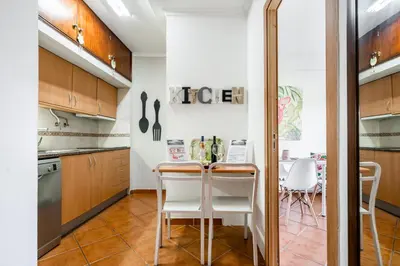 a kitchen with a table and chairs in a room at Cosy by the pool in Quarteira