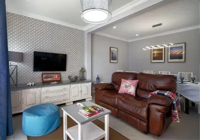 a living room with a leather couch and a tv at Bambus House Blue in Quarteira