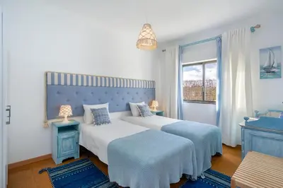 a bedroom with two beds and a window at Bambus House Blue in Quarteira