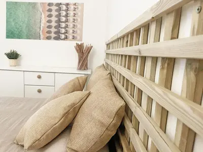 a bedroom with a wooden wall with pillows on a bed at Beachfront Oura - 100m Beach, Seaview, Garage, 300m Strip in Albufeira