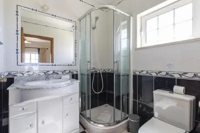 a bathroom with a shower and a sink and a toilet at Villa Tulipa in Albufeira