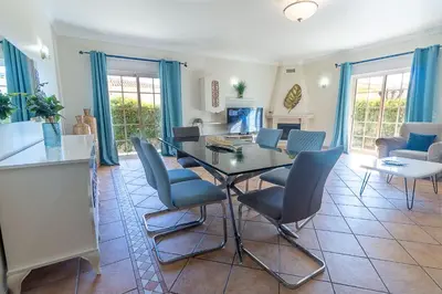 a living room with a wooden table and chairs at Villa Tulipa in Albufeira
