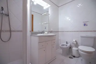 a white bathroom with a toilet and a sink at Villa Azul in Guia