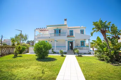a large white house with a green yard at Villa Azul in Guia