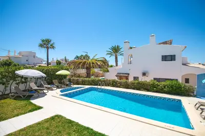 a villa with a swimming pool in front of a house at Villa Azul in Guia