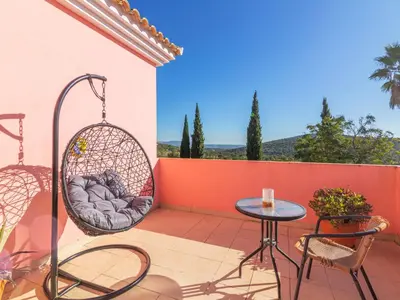 a patio with a swing and a table and chairs at Villa Villa Rosa by Interhome in Loulé