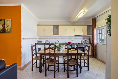 a kitchen with a table and chairs in a room at T2 Anastácio com vista Jardim in Olhos de Água