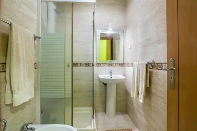 a bathroom with a sink and a toilet and a shower at T2 Anastácio com vista Jardim in Olhos de Água