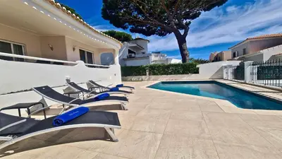 a group of lounge chairs next to a swimming pool at Villa Pinhal 213-CleverDetails- Sleeps 8, Quiet area, walking distance in Vilamoura