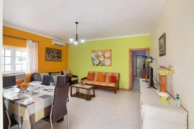 a living room with a table and a dining room at T2 Anastácio com vista Piscina in Olhos de Água