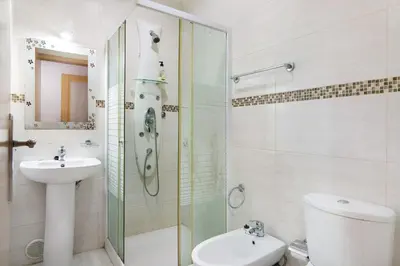 a bathroom with a shower and a toilet and a sink at T2 Anastácio com vista Piscina in Olhos de Água
