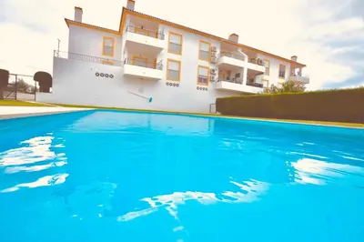 a villa with a swimming pool in front of a building at Estrada de, Urbanizacao,edificio laranjal,apartment 18,vale carro, 8200-596 in Albufeira