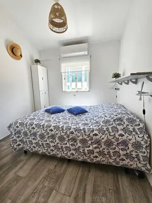 a bedroom with a bed with blue pillows on it at Casa Albufeira in Albufeira