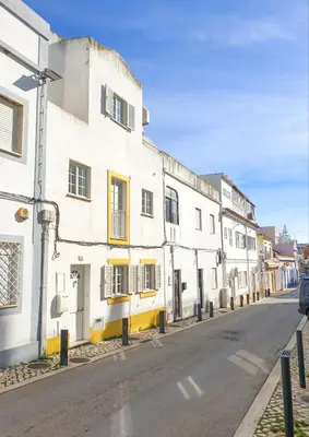 a row of white buildings on a street at Casa Albufeira in Albufeira