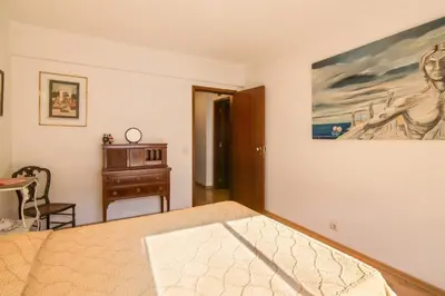 a bedroom with a bed and a painting on the wall at Apartamento Avenida da Liberdade in Albufeira