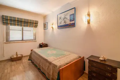 a bedroom with a bed and a dresser and a window at Apartamento Avenida da Liberdade in Albufeira