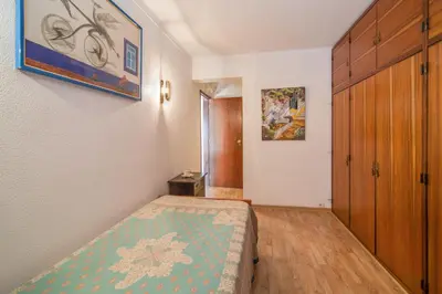 a bedroom with a bed and a wooden cabinet at Apartamento Avenida da Liberdade in Albufeira