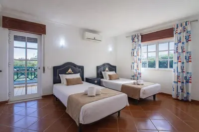 two beds in a room with red walls and a window at Villa Pacheco in Albufeira
