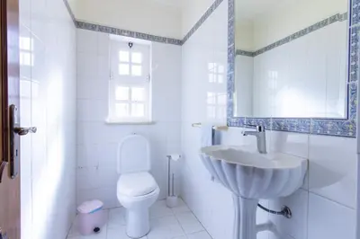a bathroom with a sink and a mirror and a toilet at Villa Pacheco in Albufeira