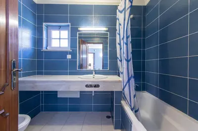 a blue tiled bathroom with a sink and a tub at Villa Pacheco in Albufeira