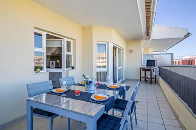 a dining room with a table and chairs on a balcony at Vilamoura Boutique Apartment in Quarteira