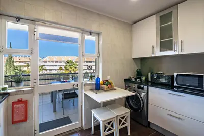 a small kitchen with a table and a window at Vilamoura Boutique Apartment in Quarteira