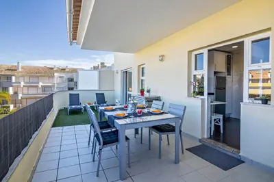 a patio with a table and chairs on a balcony at Vilamoura Boutique Apartment in Quarteira
