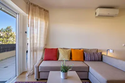 a living room with a couch with colorful pillows at Vilamoura Boutique Apartment in Quarteira