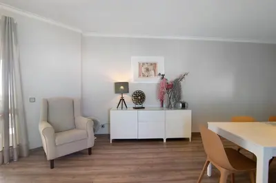 a white living room with a table and a chair at Palmeira Galé in Galé