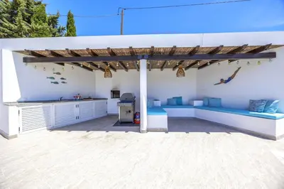 a patio with a blue couch under a pergola at Private Oasis in Algarve with Pool & Fruit Garden in Loulé