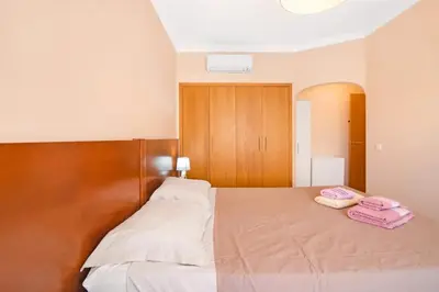 a bedroom with a large white bed with a window at Almancil Park Apartment in Almancil
