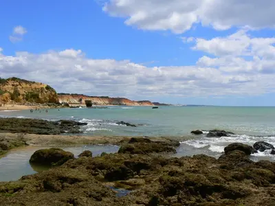 a beach with rocks and people in the water at Duplex Varandas Do Mar Patricia Vista Mar - 50 metros Praia Olhos de Água in Albufeira