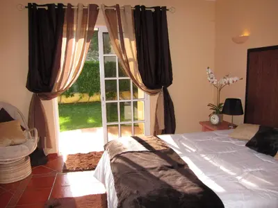 a bedroom with a bed in front of a window at 5 Bedroom Private Villa Tenazinha III, pool, garden, BBQ in Albufeira