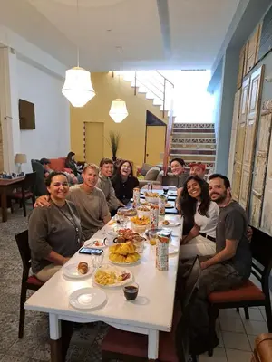 a room with a bunk bed and a table and a bench at Tilia Hostel in Faro
