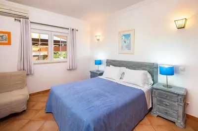 a bedroom with a blue bed and a chair at GR 2 X Private Villas Private Pools - Up to 20 Guests in Albufeira
