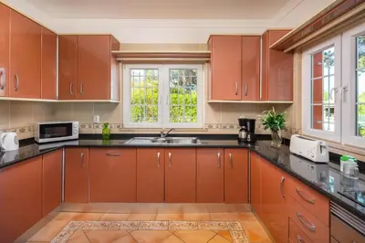 a kitchen with brown cabinets and a sink at GR 2 X Private Villas Private Pools - Up to 20 Guests in Albufeira