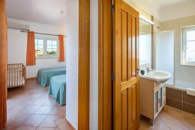 a bathroom with a sink and a bed in a room at GR 2 X Private Villas Private Pools - Up to 20 Guests in Albufeira