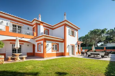 a large orange and white house with a yard at GR 2 X Private Villas Private Pools - Up to 20 Guests in Albufeira
